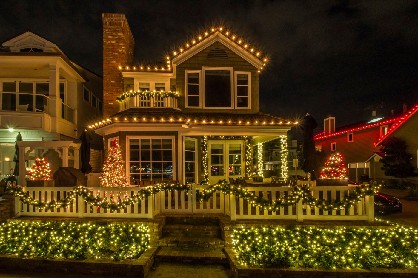 Christmas lighting installed along a home roofline at dusk
