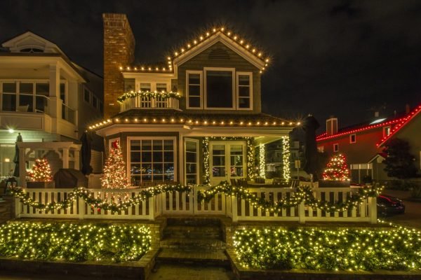 Full roofline of a house outlined in Christmas lights